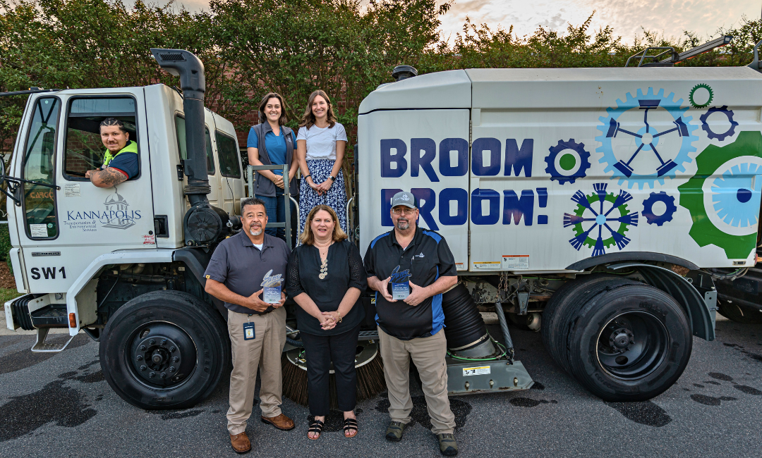 Savvy winners in front of leaf vacuum truck 